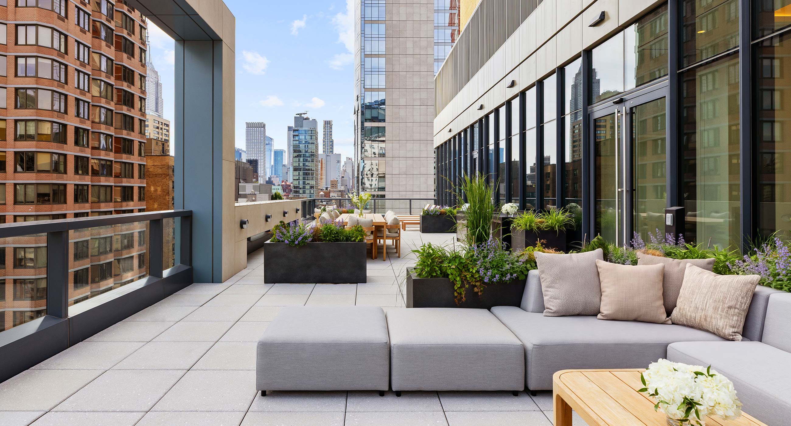Rooftop terrace at The Lotus NYC in Murray Hill featuring outdoor seating and iconic Manhattan skyline views.